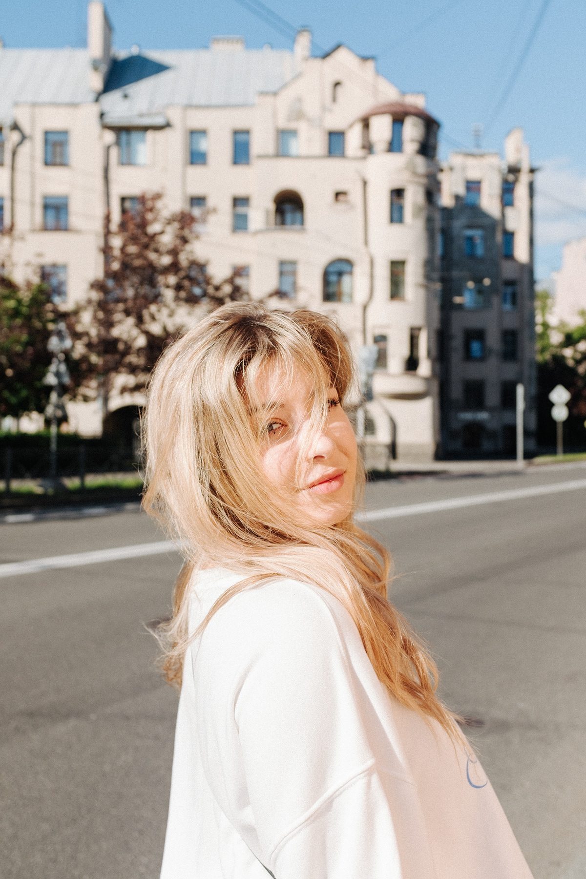 Portrait in early morning sun on an empty street, art nouveau façade behind