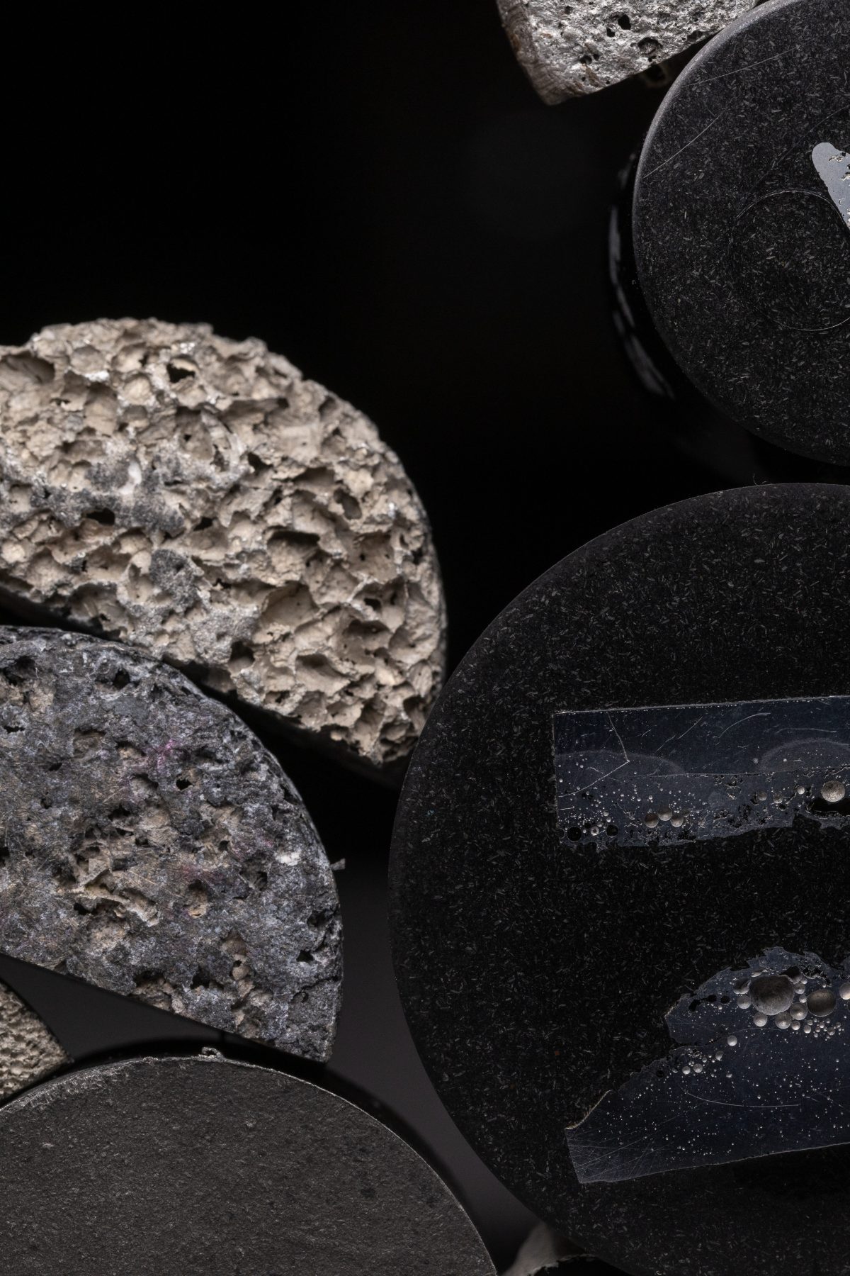 Macro of a porous ceramic fracture surface lit from the left against black
